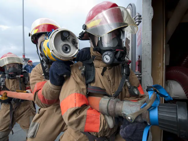 The image shows a group of firefighters wearing helmets, gloves, and protective gear, with one of...