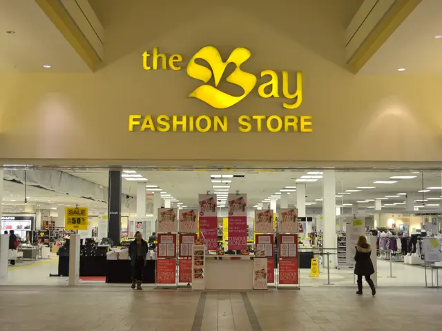 The image shows a bay fashion store in a shopping mall, with people walking on the floor, boards...