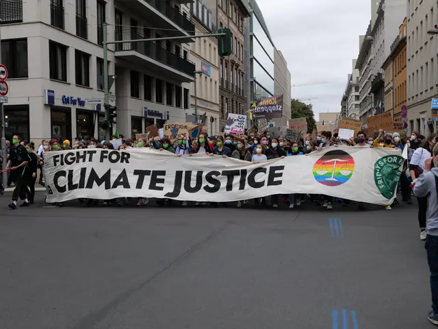 The image shows a group of people walking down a street, holding a banner that reads "Fight for...