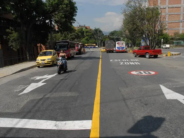 This picture shows a few buildings and trees and we see few vehicles moving on the road and we see...