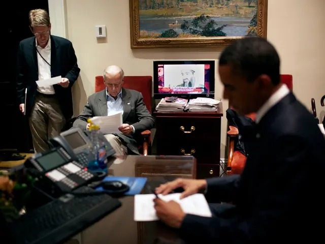 The image shows President Obama sitting at a desk in the Oval Room of the White House, surrounded...