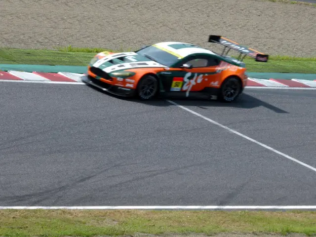 The image shows an Aston Martin V12 Vantage GT3 on the racetrack, surrounded by lush green grass.