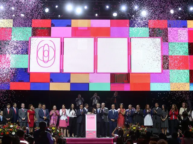 The image shows a group of people standing on top of a stage, with a podium in front of them. There...