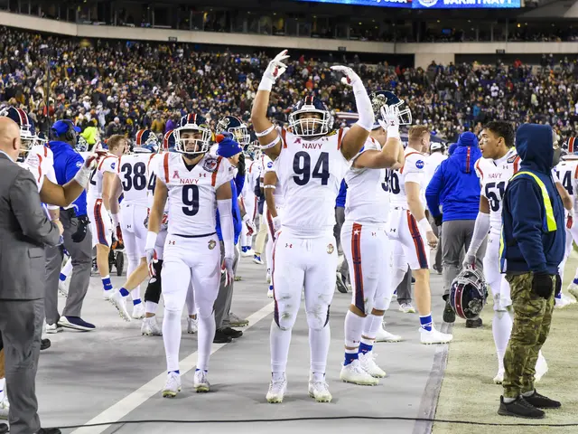 The image shows a group of men standing on top of a football field, wearing helmets and gloves. In...