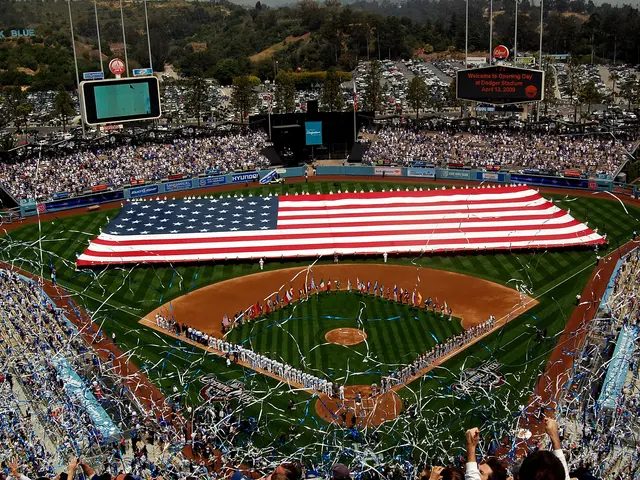 The image shows a baseball stadium filled with lots of people, some standing and some sitting, with...
