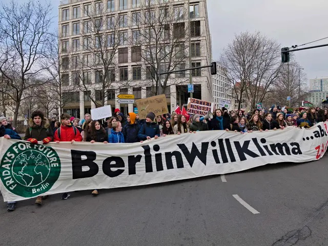 The image shows a group of people walking down a street, holding a banner that reads "Berlin...