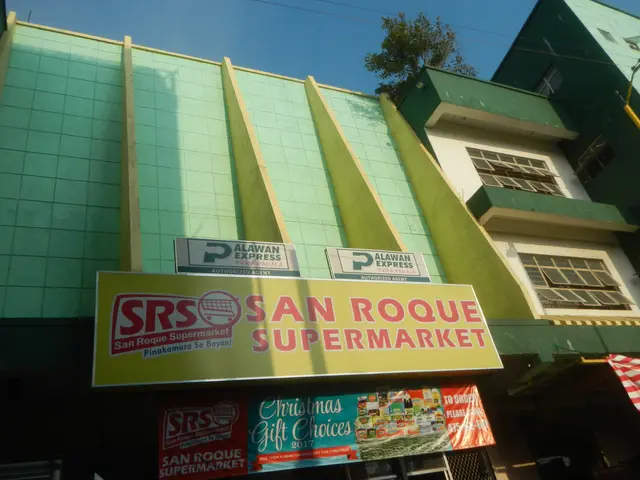 The image shows the San Roque Supermarket in Manila, Philippines. It is a building with windows, a...