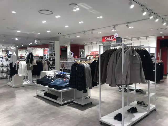 The image shows the inside of a clothing store with mannequins, clothes on hangers, shoes on the...