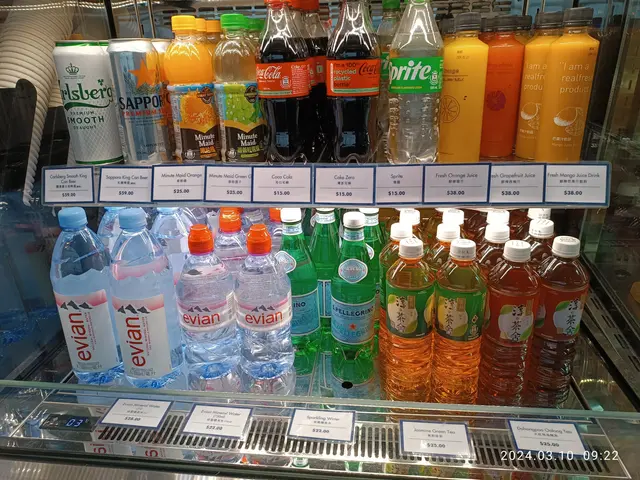The image shows a display case filled with lots of different types of drinks, including bottles and...