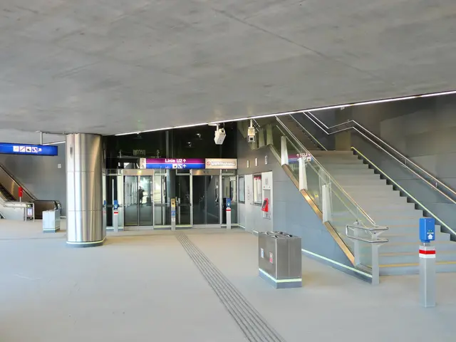 The image shows an empty train station with stairs and railings, dustbins on the floor, boards with...