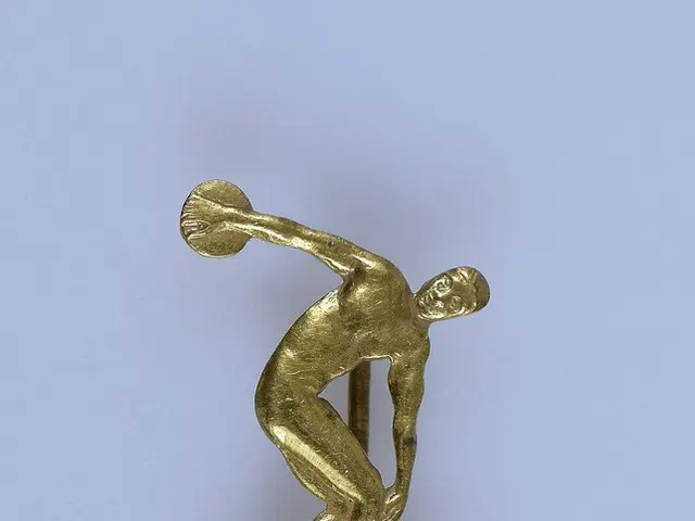 The image shows a gold medal with a man throwing a discus on a stick, with the text "1909-1959"...