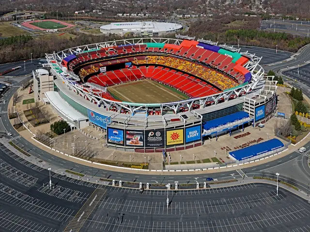 The image shows an aerial view of a football stadium in the middle of a city, surrounded by...