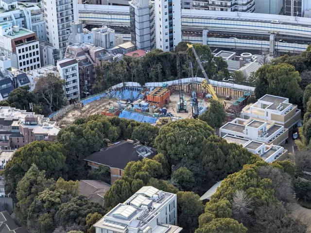 The image shows an aerial view of a construction site in the middle of a city, with buildings,...