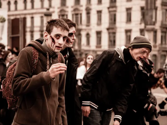 The image shows a group of people dressed up as zombies walking down a street, with a building in...