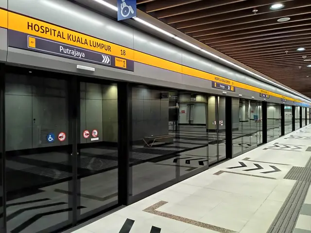 The image shows a subway station with a train on the tracks, illuminated by lights on the ceiling....