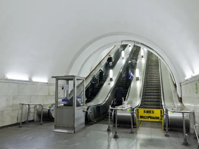 The image shows an escalator in a subway station with people on it, surrounded by railings, boards...