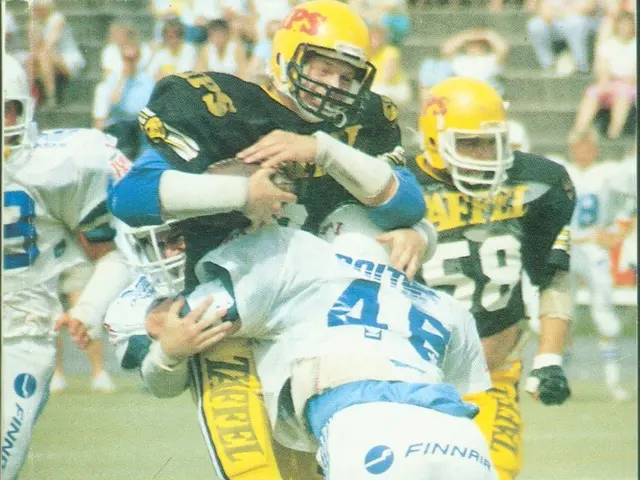The image shows a group of people wearing sports dress and helmets playing football on a field,...