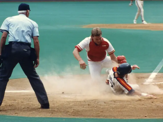 The image shows a baseball player sliding into home plate during a game. We can see the player...