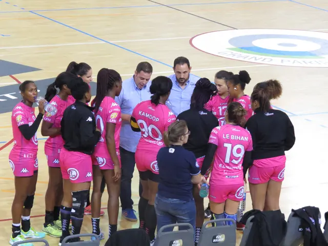 The image shows a group of women standing on top of a basketball court, with some of them holding...