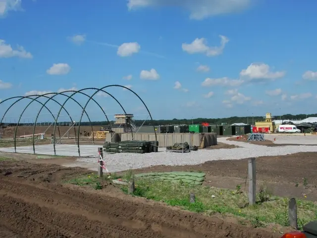 The image shows a construction site with a large metal structure in the middle of it, surrounded by...