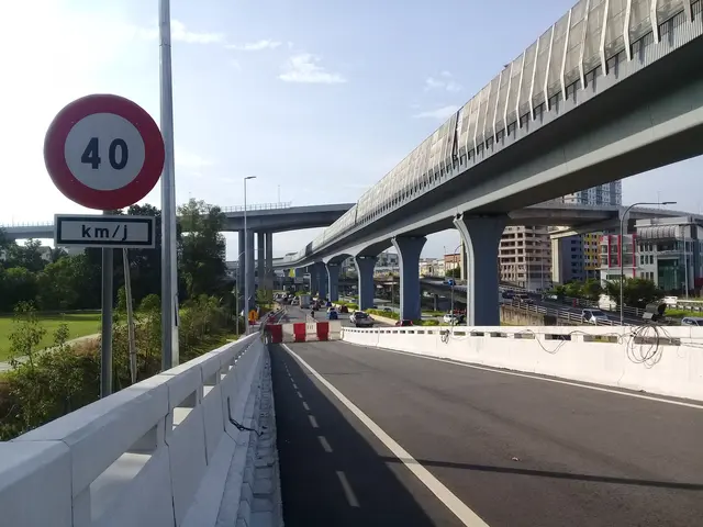 The image shows a highway with a speed limit sign on the side of it, surrounded by vehicles on the...