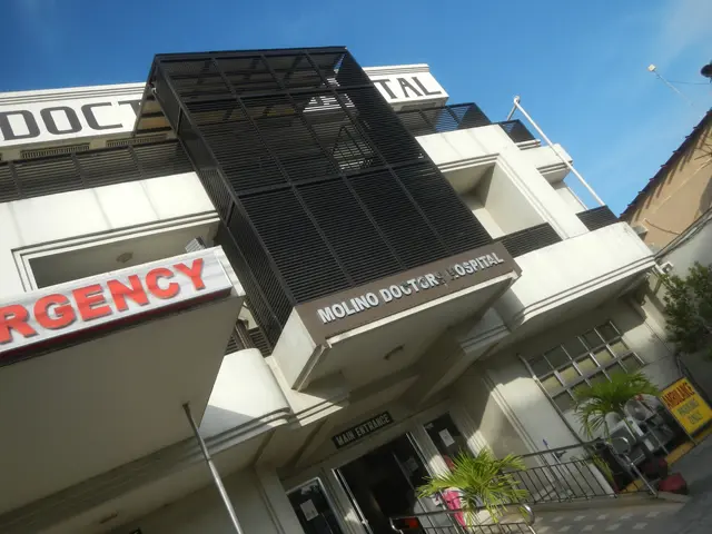 The image shows a building with a sign that reads "Emergency" on the side of it, surrounded by...