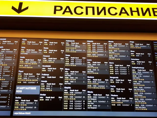 The image shows an airport departure board with a yellow sign above it. The board is filled with...