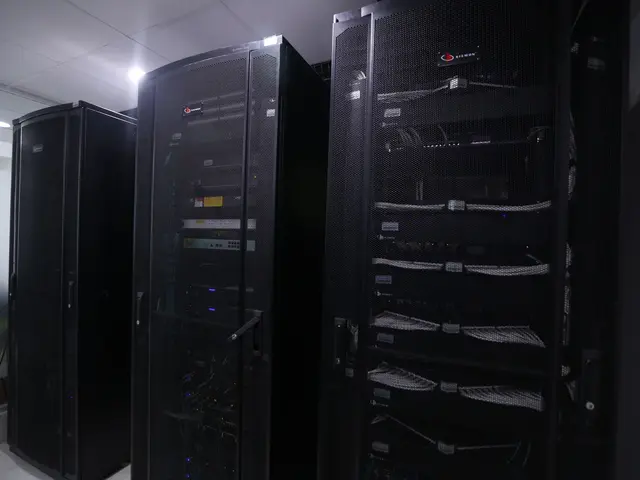 The image shows a row of servers in a data center, with a wall on the right side and a ceiling with...
