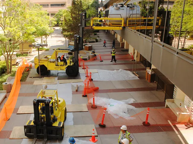 The image shows a group of construction workers wearing helmets and safety jackets working on a...