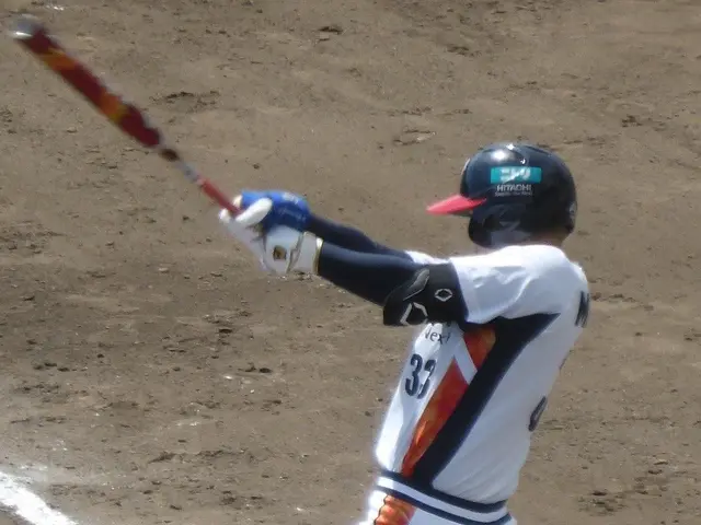 The image shows a baseball player wearing a helmet and gloves, swinging a bat on top of a field.