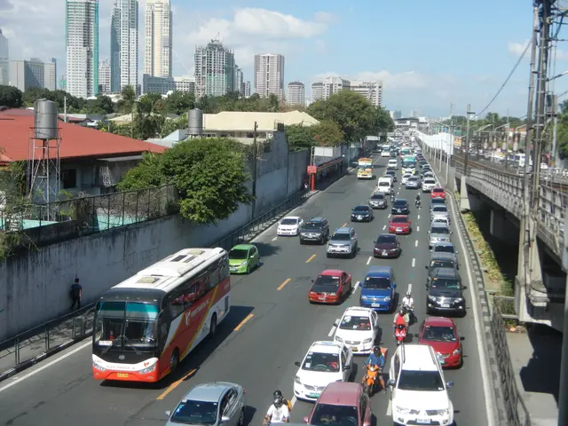 The image shows a city street filled with lots of traffic, including cars and buses, as well as...