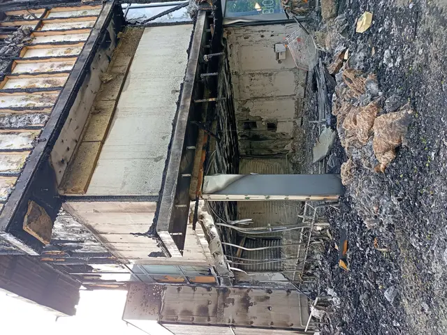 The image shows the remains of a building that has been destroyed by a fire, with the ground on the...
