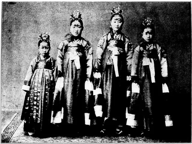 The image shows a group of four women standing next to each other, all wearing traditional Korean...