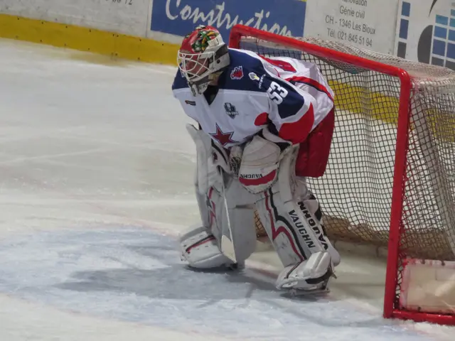 The image shows a hockey player in a goalie's net on the ice, wearing a sports uniform, helmet,...