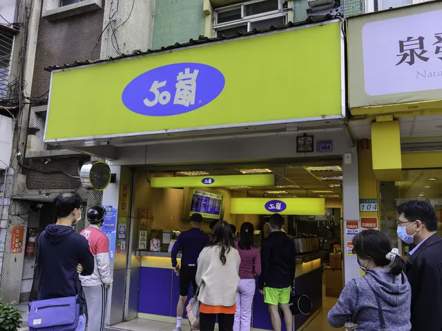 The image shows a group of people standing in front of a store with windows, sign boards with text,...
