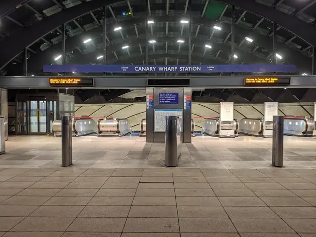The image shows a subway station with a lot of metal detectors on the floor, bollards, boards with...