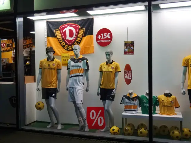 The image shows a store window display with mannequins wearing yellow and black soccer uniforms, a...