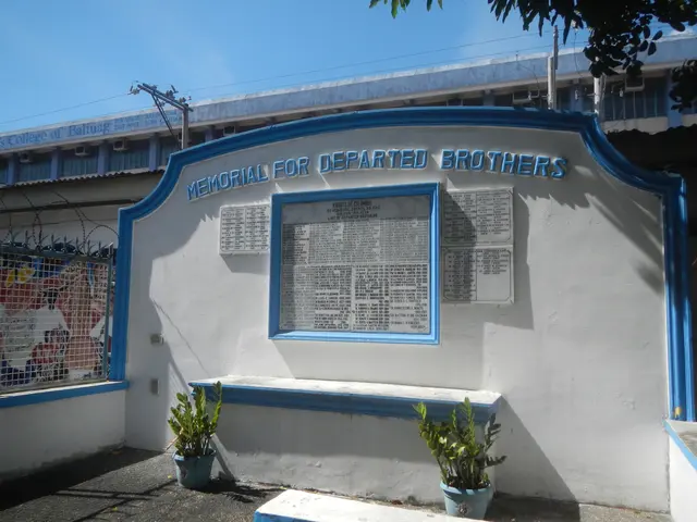 The image shows a memorial for departed brothers in front of a building, with a name board on the...