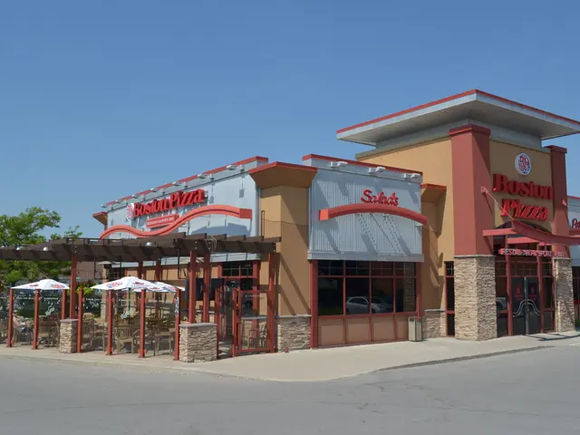 The image shows a Boston Pizza restaurant on the corner of a street, with a road in front of it....