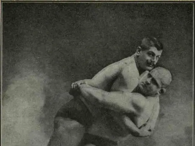 The image shows an old black and white photo of two men wrestling, with one of them holding the...