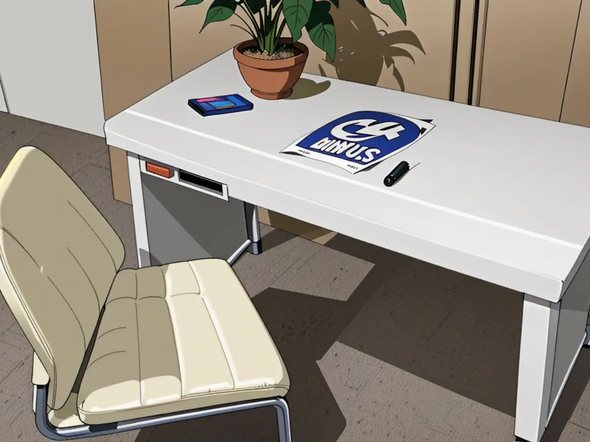 Image of a white desk chair positioned against a white desk in the foreground.