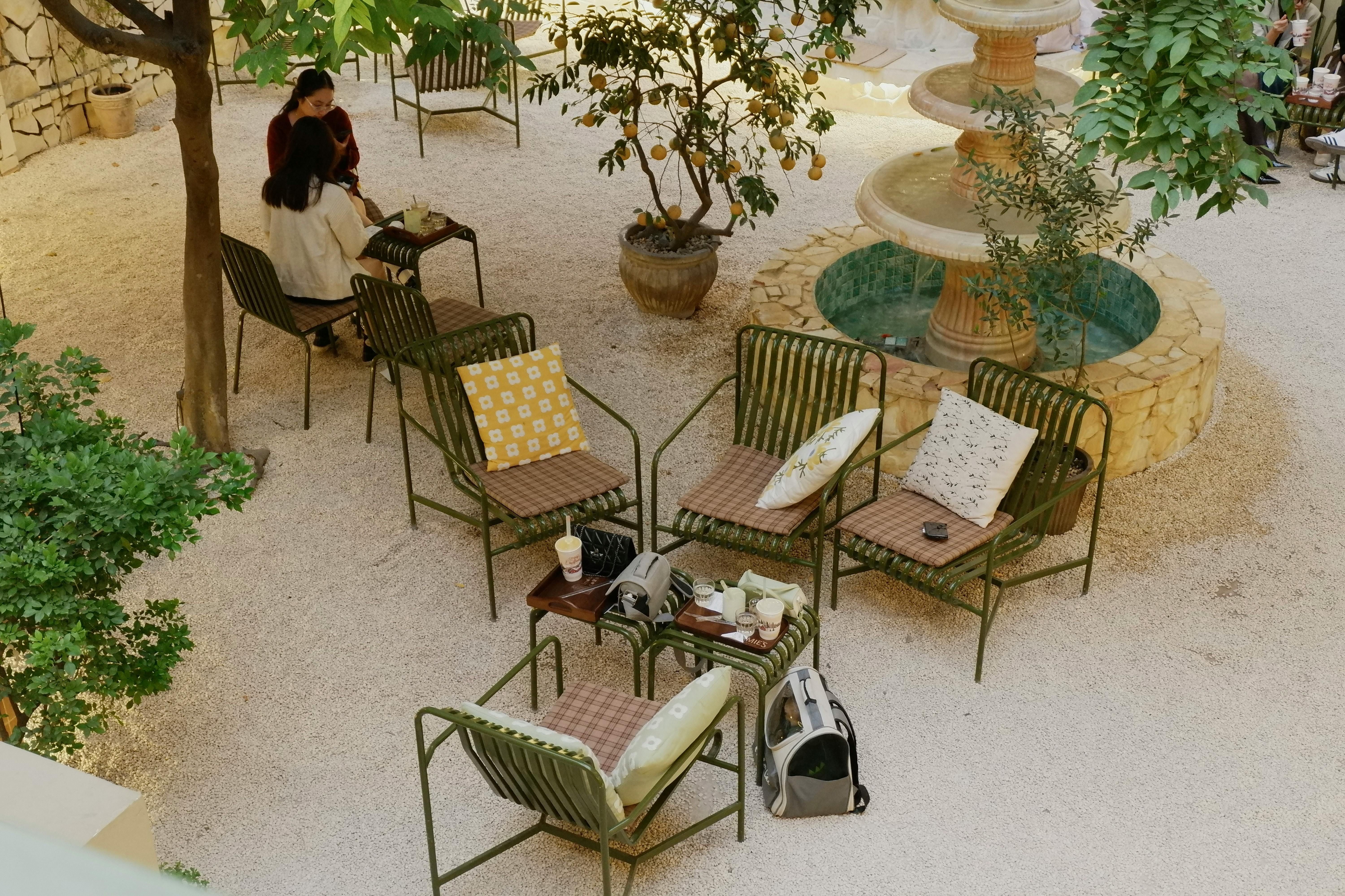 Patio features outdoor sectional couch and cushions nearby, accompanied by potted plant on a coffee table. Patio furnished with a sectional sofa and cushions, featuring a plant on a coffee table nearby.