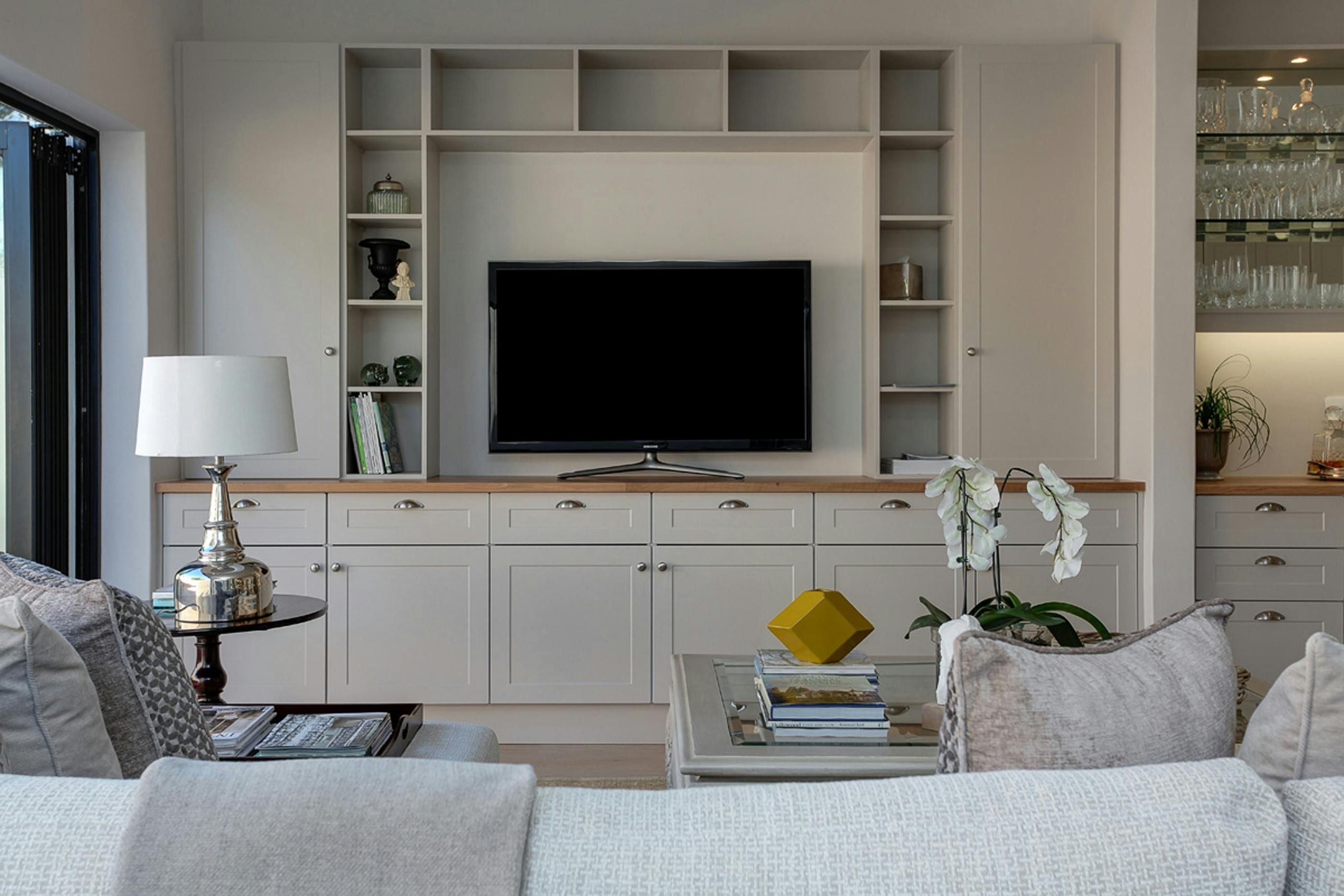 Living room display featuring various items nestled within a bookshelf. Living space showcasing a cluttered bookshelf containing various articles.