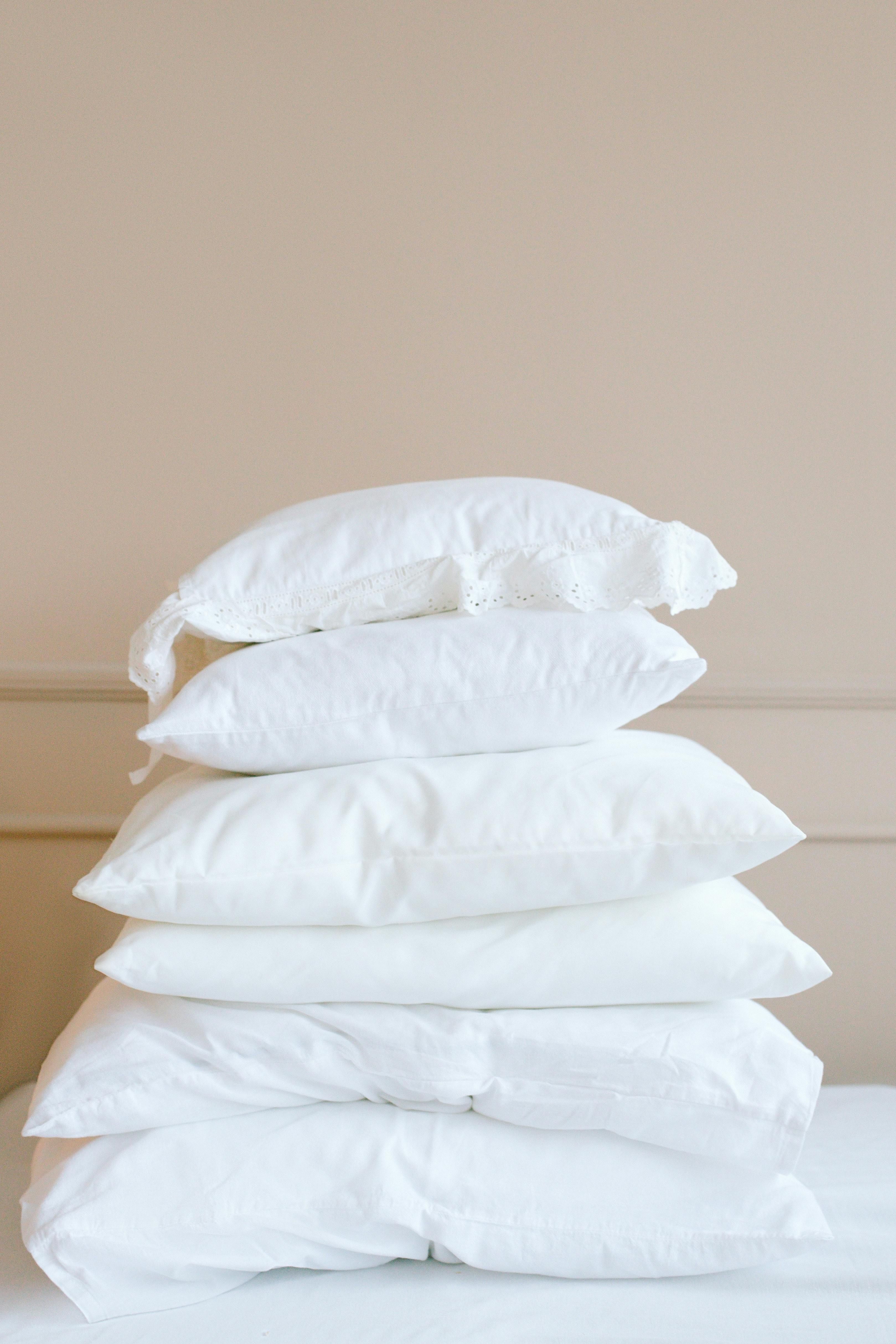 Stored possessions found within a pile of pillows and coverings, alongside a pair of ice skates. Items enclosed in vacuum bags found amidst a pile of pillows and blankets, alongside ice skates.