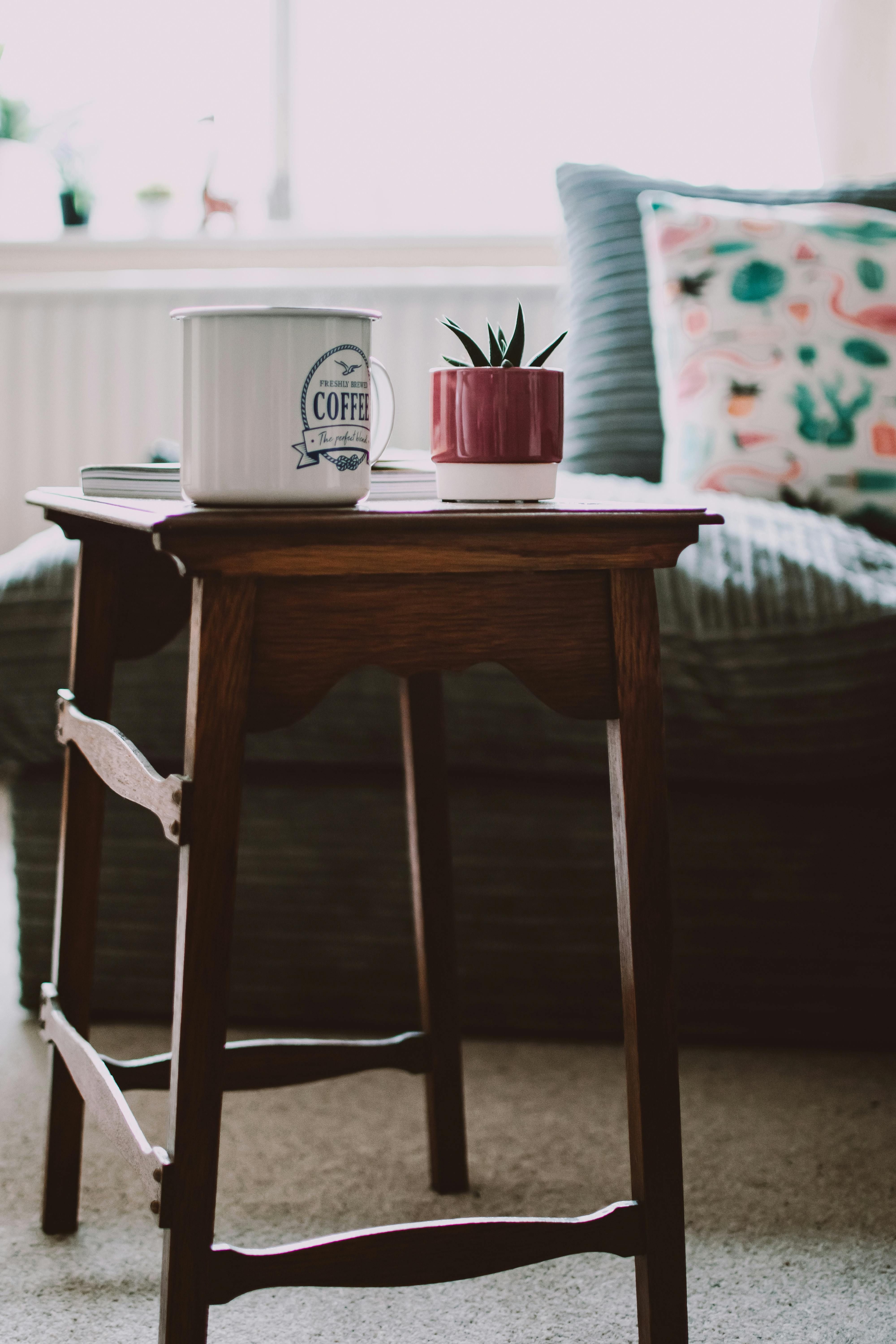 Table situated in a space, shared with a couch and a complementary coffee table Table adjacent to a living area furnished with a couch and a coordinating coffee table