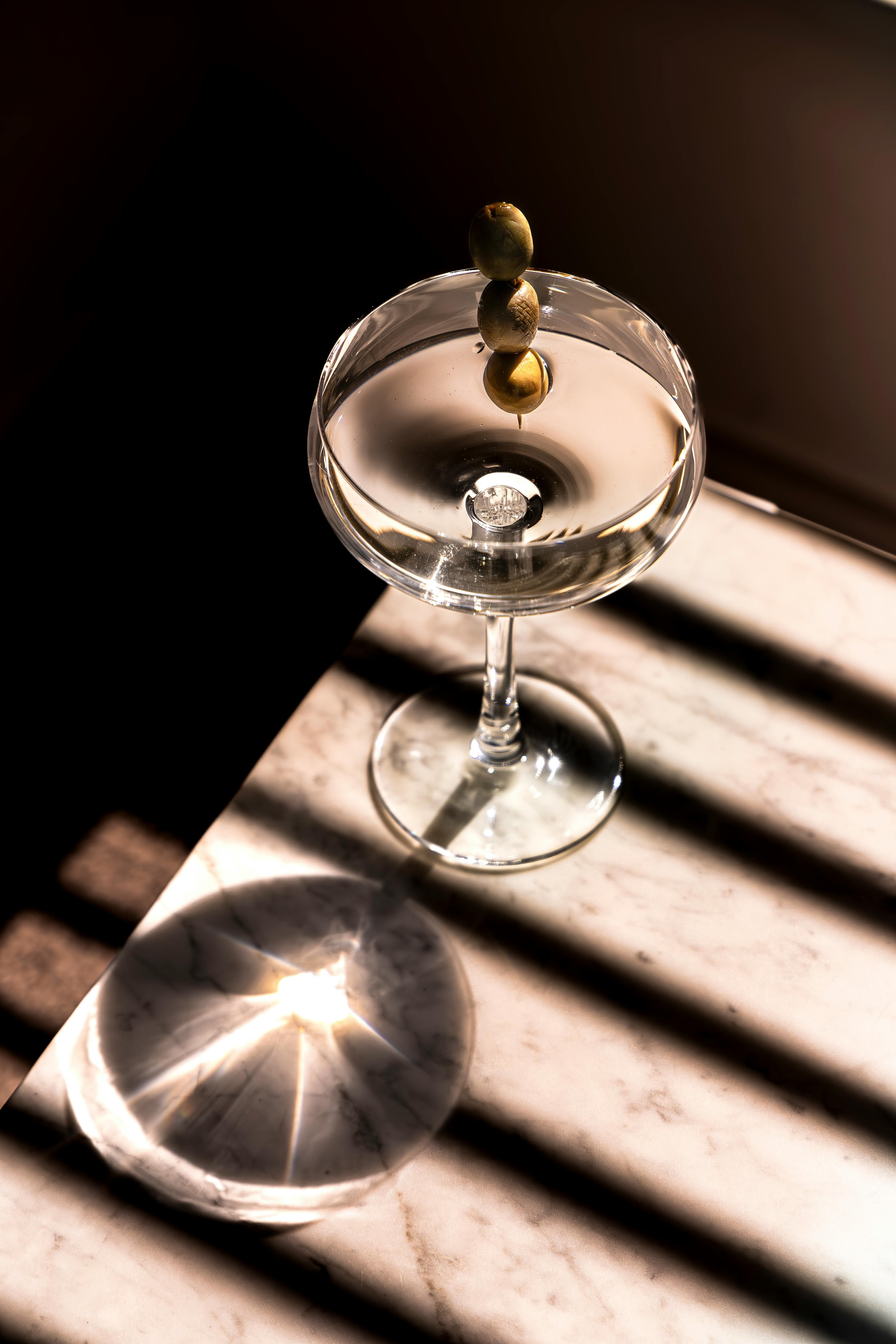 Cocktail kits, TSA-compliant, neatly arranged on a marble table alongside a highball glass containing a cocktail Assortment of TSA-approved cocktail sets displayed on a marble table, alongside a prepared highball drink