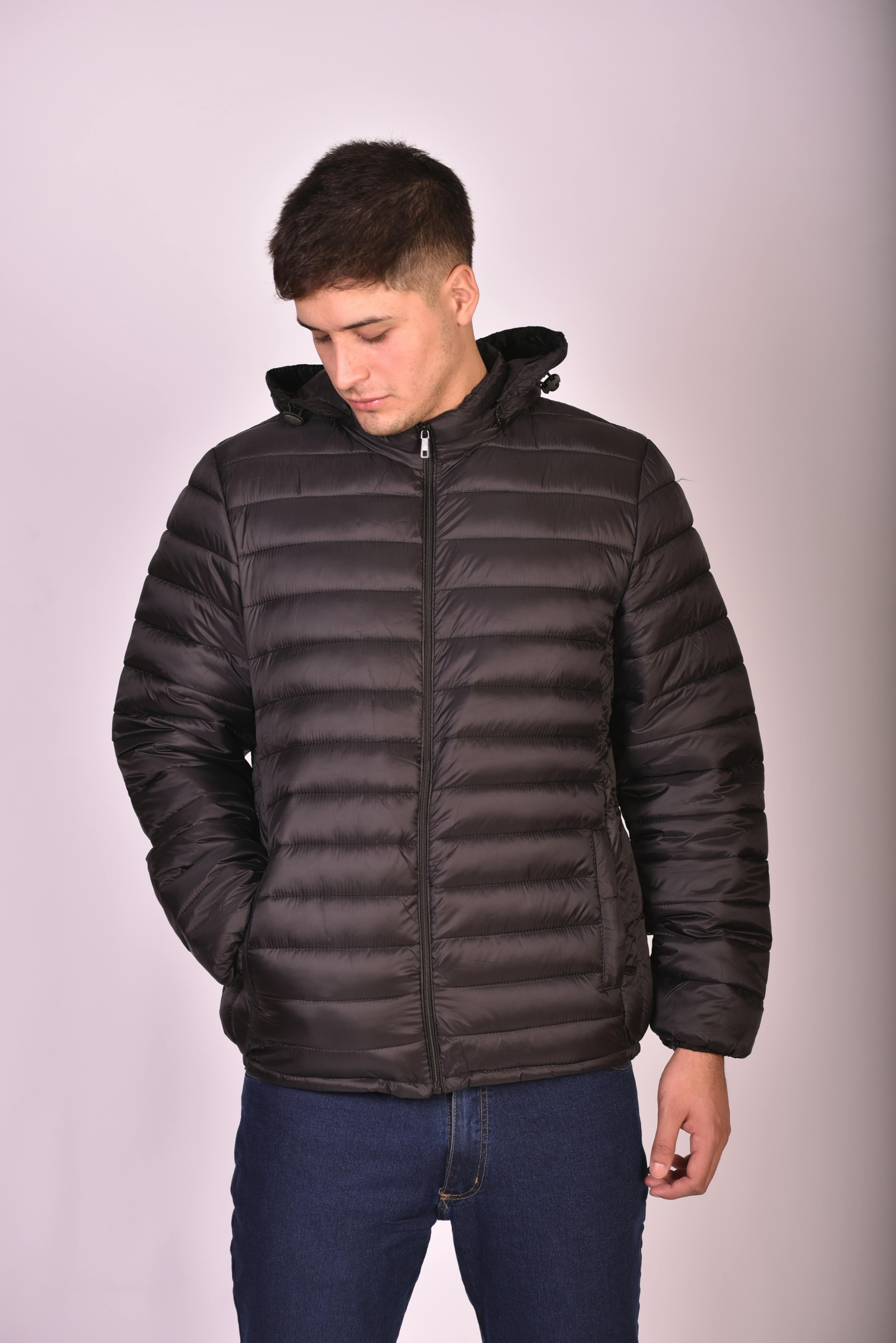 Individual sporting a matt-black, puffer-style leather jacket. Individual sporting a sleek, black puffer coat, resembling leather.
