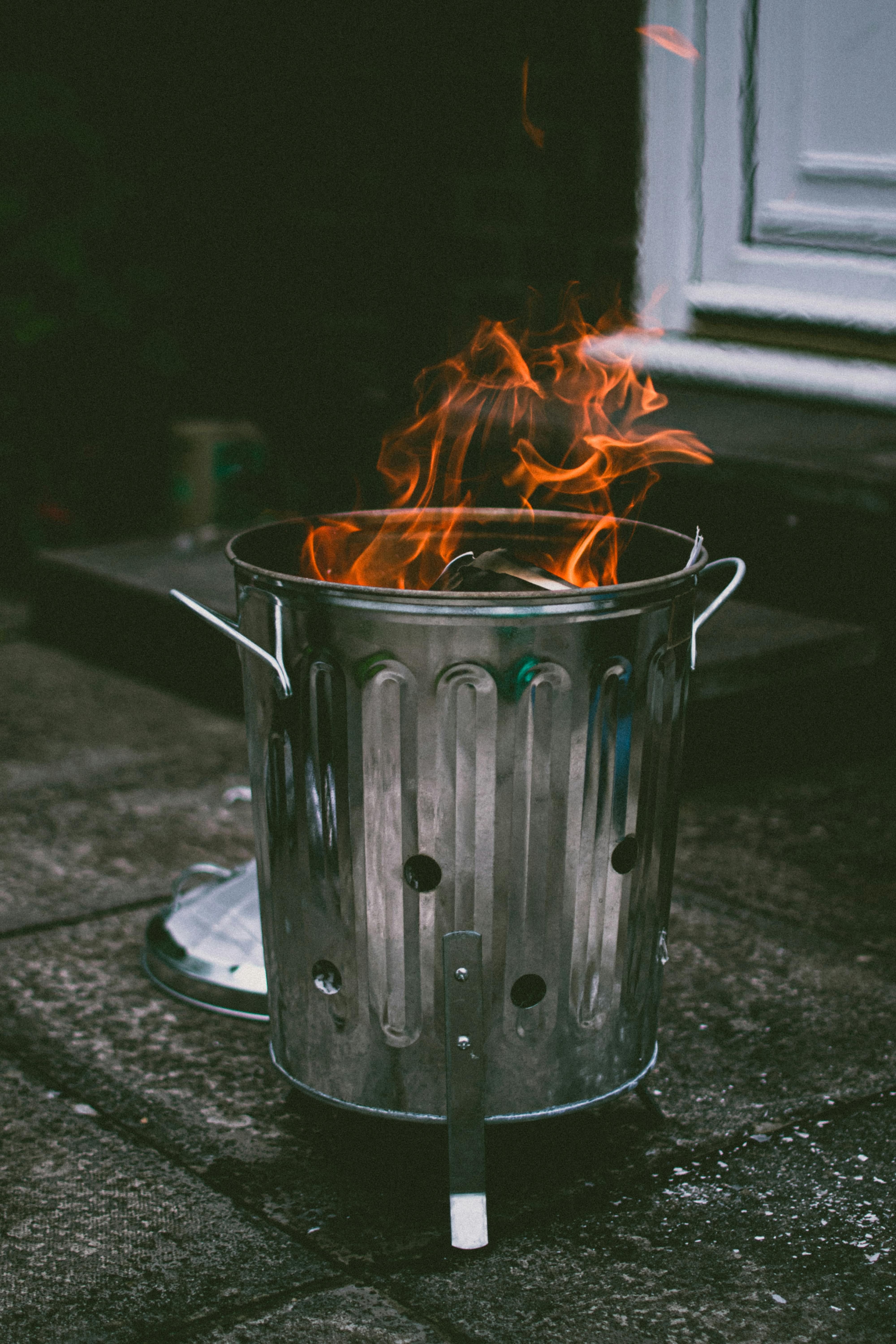 Examiner's Thorough Inspections of Soiled Stainless Steel Waste Bin Assessing the grime-laden, stainless steel waste compactor scrutinized by a critic.