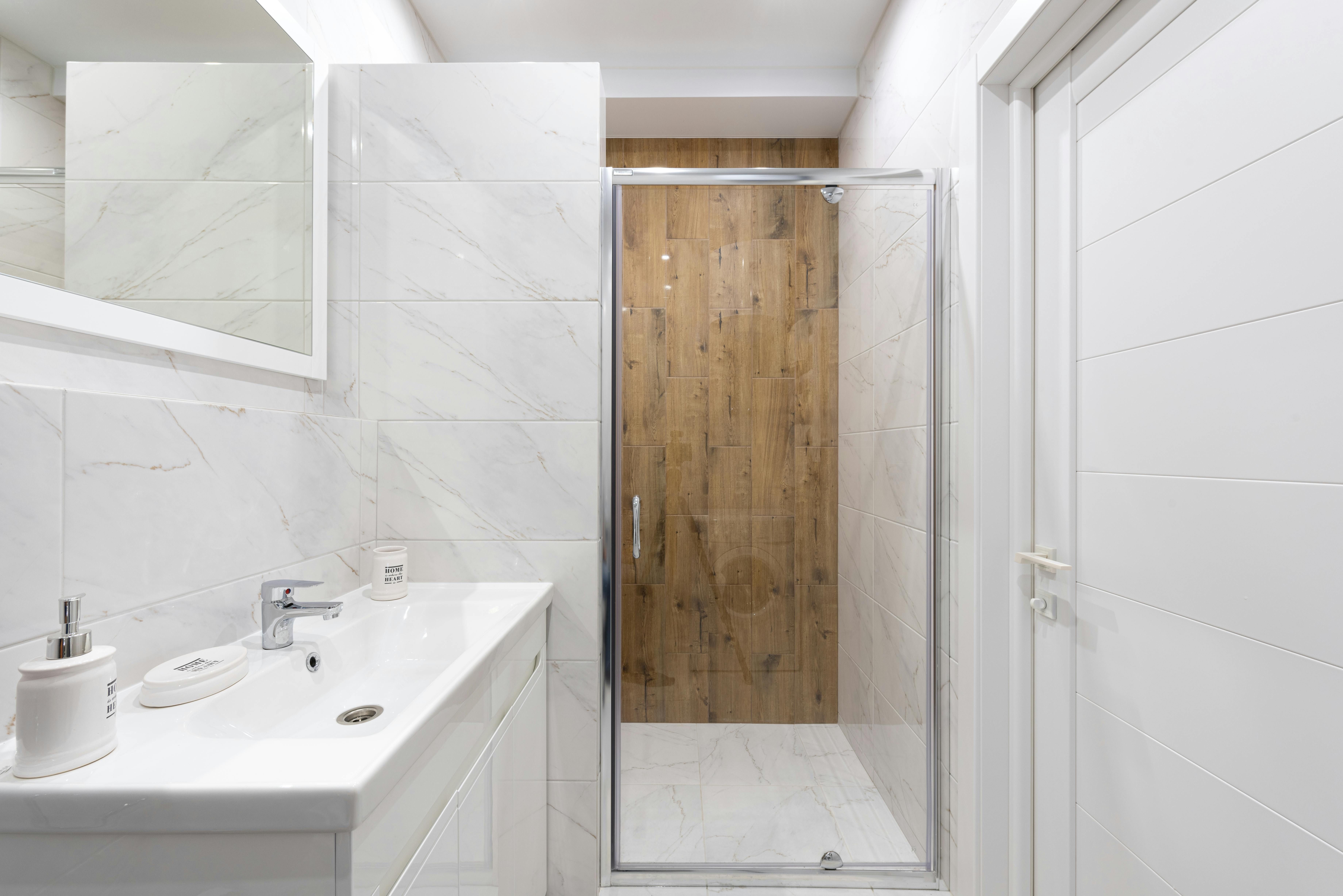 Unsanitary shower door: Obscured view on one side due to mineral and soap accumulation, while the other side remains clear. Dirty, Opaque Shower Door vs. Clear, Transparent Shower Door: A Reviewer's Observation (with focus on one panel containing mineral and soap buildup)