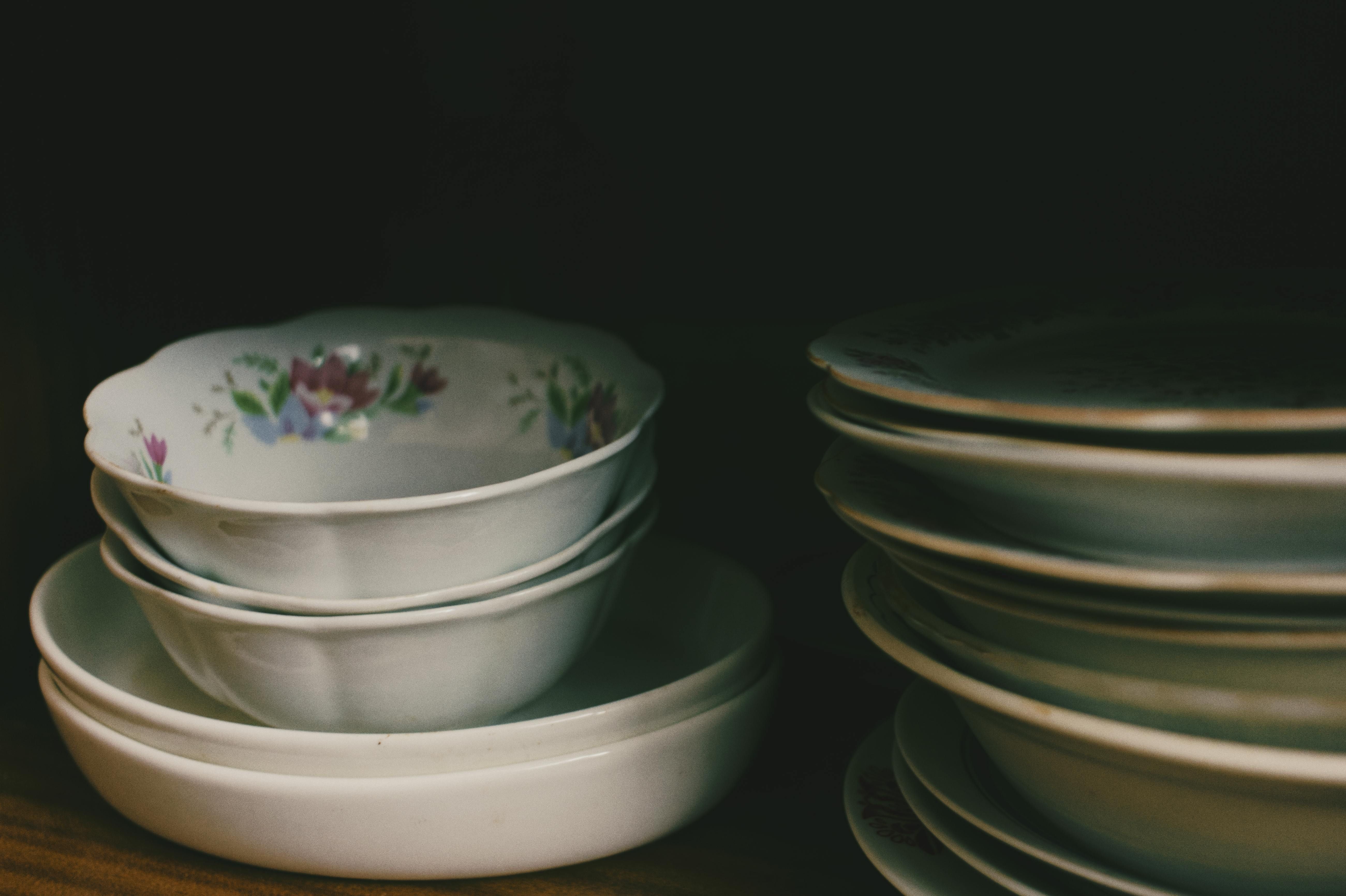 Stacked dishes in a cabinet Dishes piled high within a cabinet.